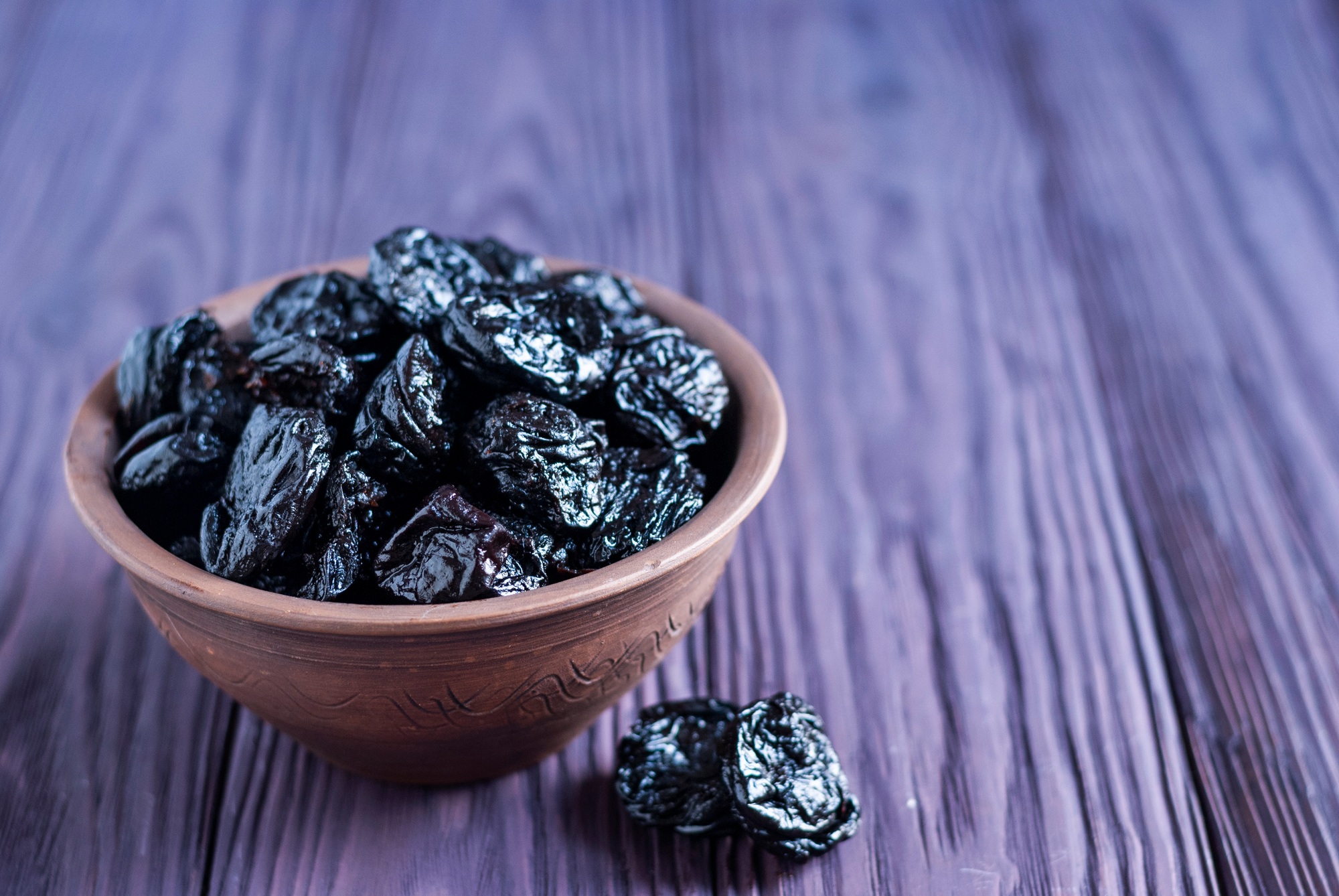 Heap of juicy prunes in bowl